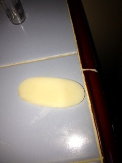 Oval yellow sponge on glossy white tile countertop