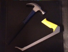 Claw hammer and pry bar on black background