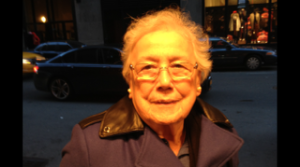 Smiling elderly man in coat on city street